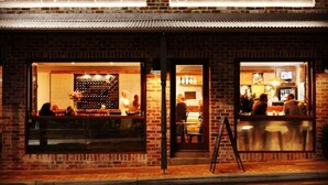 Un bâtiment en briques abritant un café et un bar à vin appelé « Trio ».