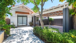 A modern house with a covered patio, a garage, and a well-maintained garden.