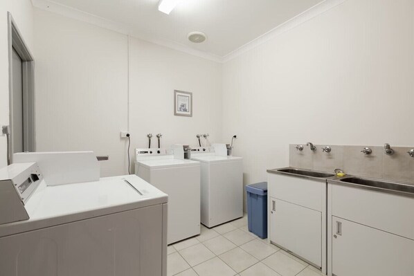 A laundry room with a washing machine, dryer, and a sink.