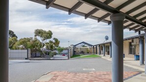 A covered outdoor area with a brick pathway, a gated entrance, and a building with satellite dishes. - A5 - Bright & spacious, 1 bathroom apartment! (Connolly)
