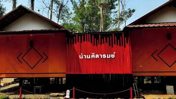 Ein Gebäude mit roter Fassade und thailändischen Schriftzeichen.