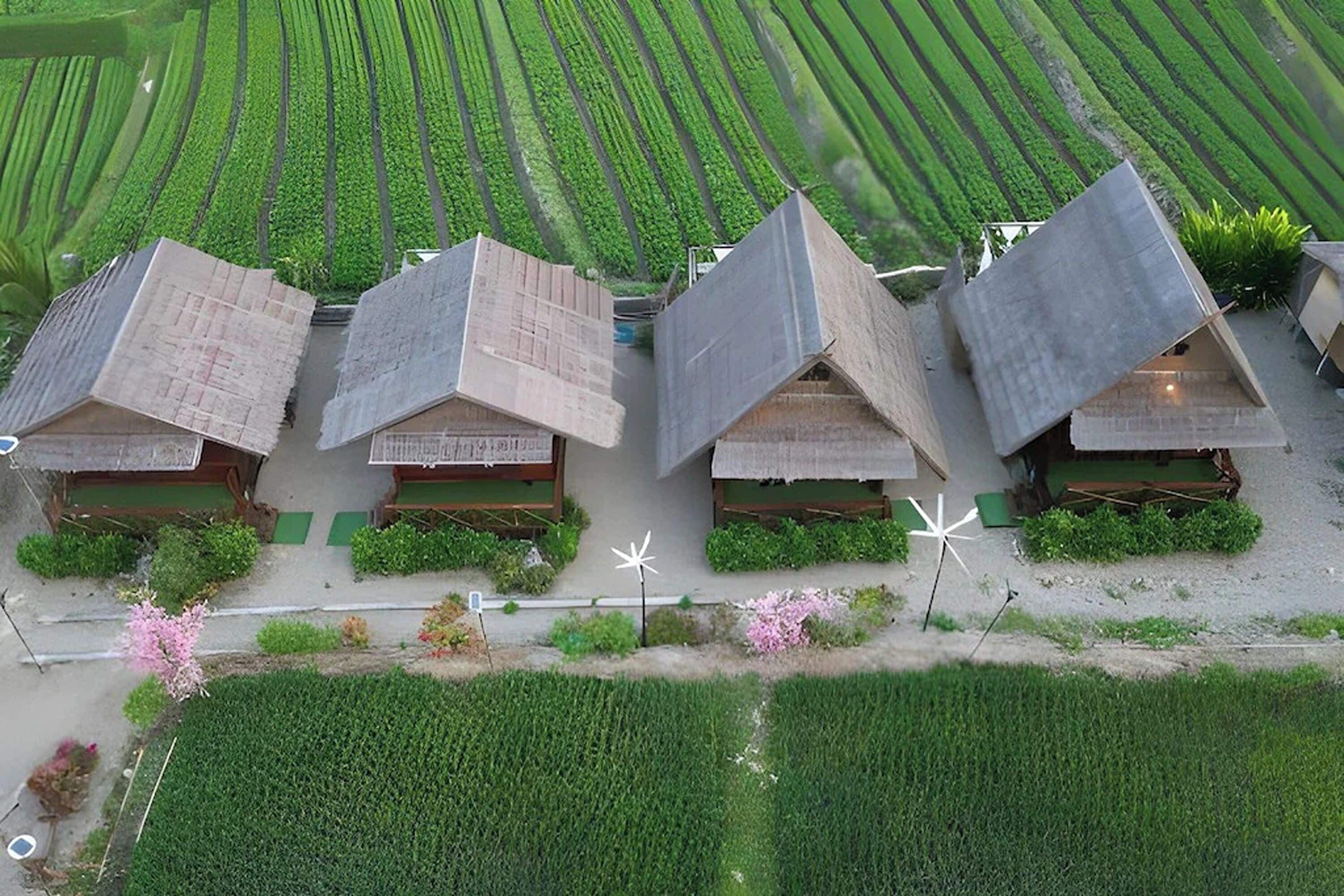 A row of traditional-style houses with sloped roofs, arranged in a linear fashion on a flat landscape.