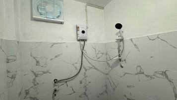 A bathroom with a shower, a wall-mounted fan, and a marble-patterned wall.