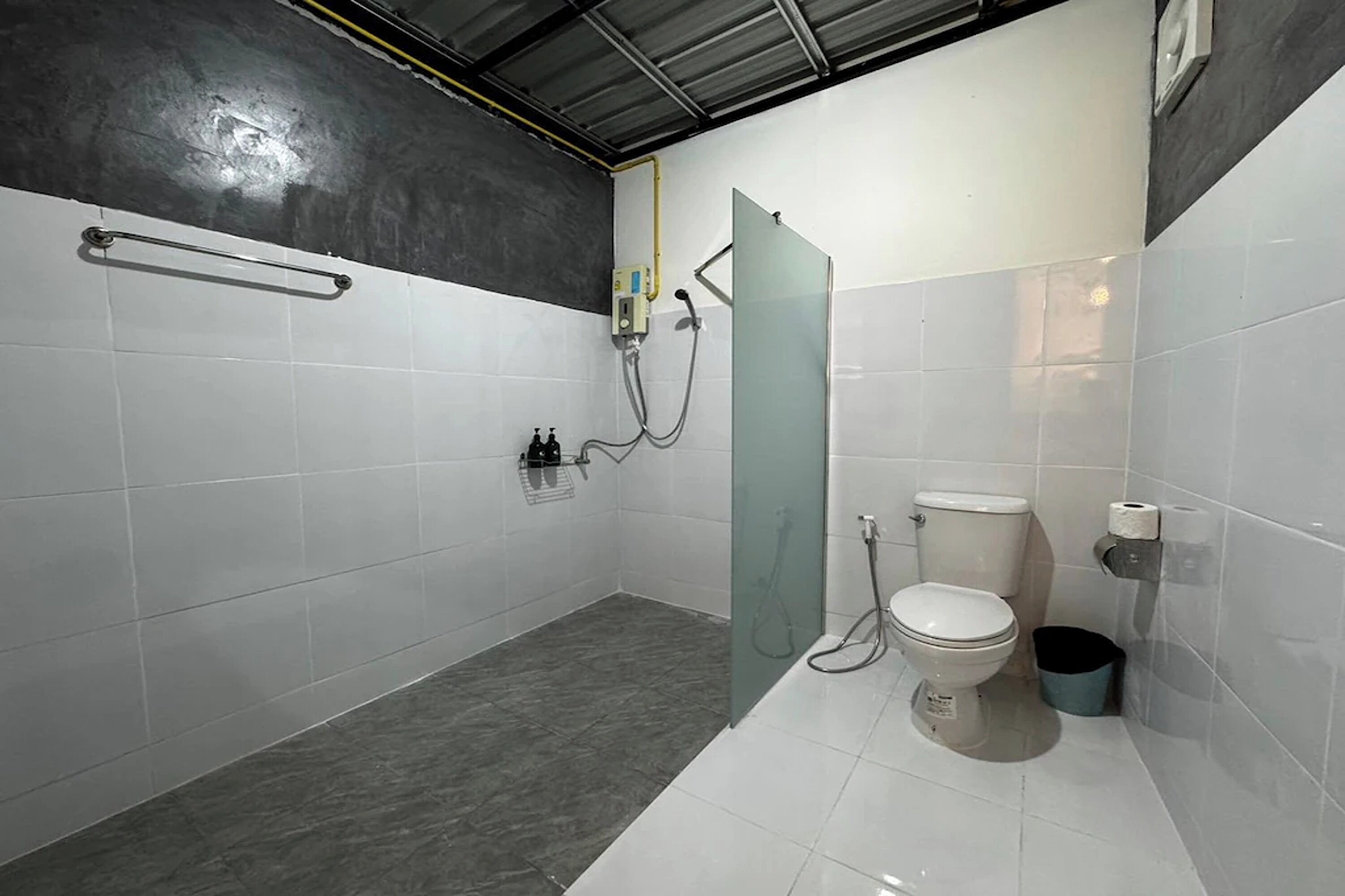 A modern bathroom with a glass shower enclosure, a toilet, and a sink.