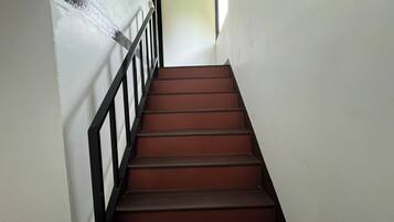 Una escalera con barandilla negra y escalones marrones.