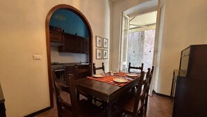 A dining area with a wooden table, chairs, and a kitchen in the background. - Apartment in Chiavari (Chiavari)