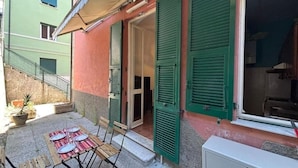 A small outdoor patio with a table set for two, a bench, and a potted plant. - Apartment in Chiavari (Chiavari)