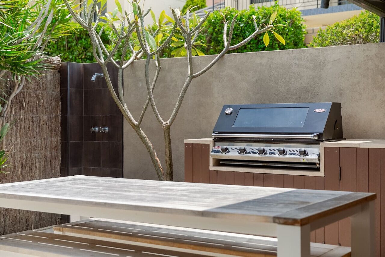 Un espace barbecue extérieur avec une table au premier plan.