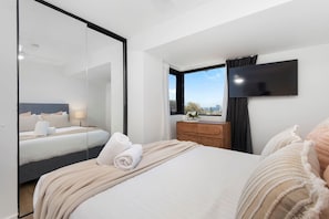 2 habitaciones, escritorio y tabla de planchar con plancha