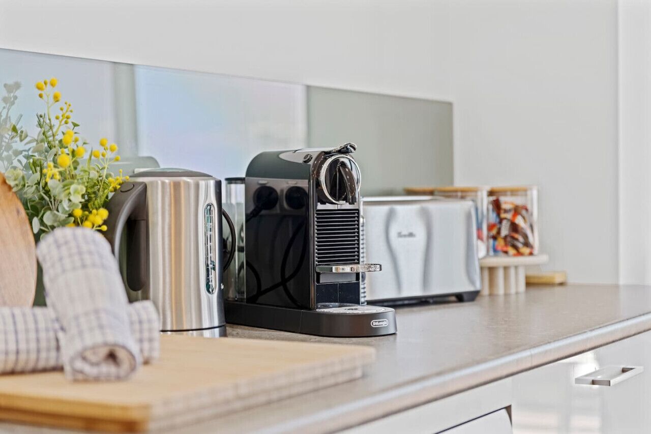 A kitchen with a toaster, a coffee maker, and a toaster oven on the counter.