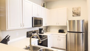 A modern kitchen with white cabinets, stainless steel appliances, and a sink. - BB614NPP - Relaxing 3BR Corner Condo • Sleeps 6 (Davenport)