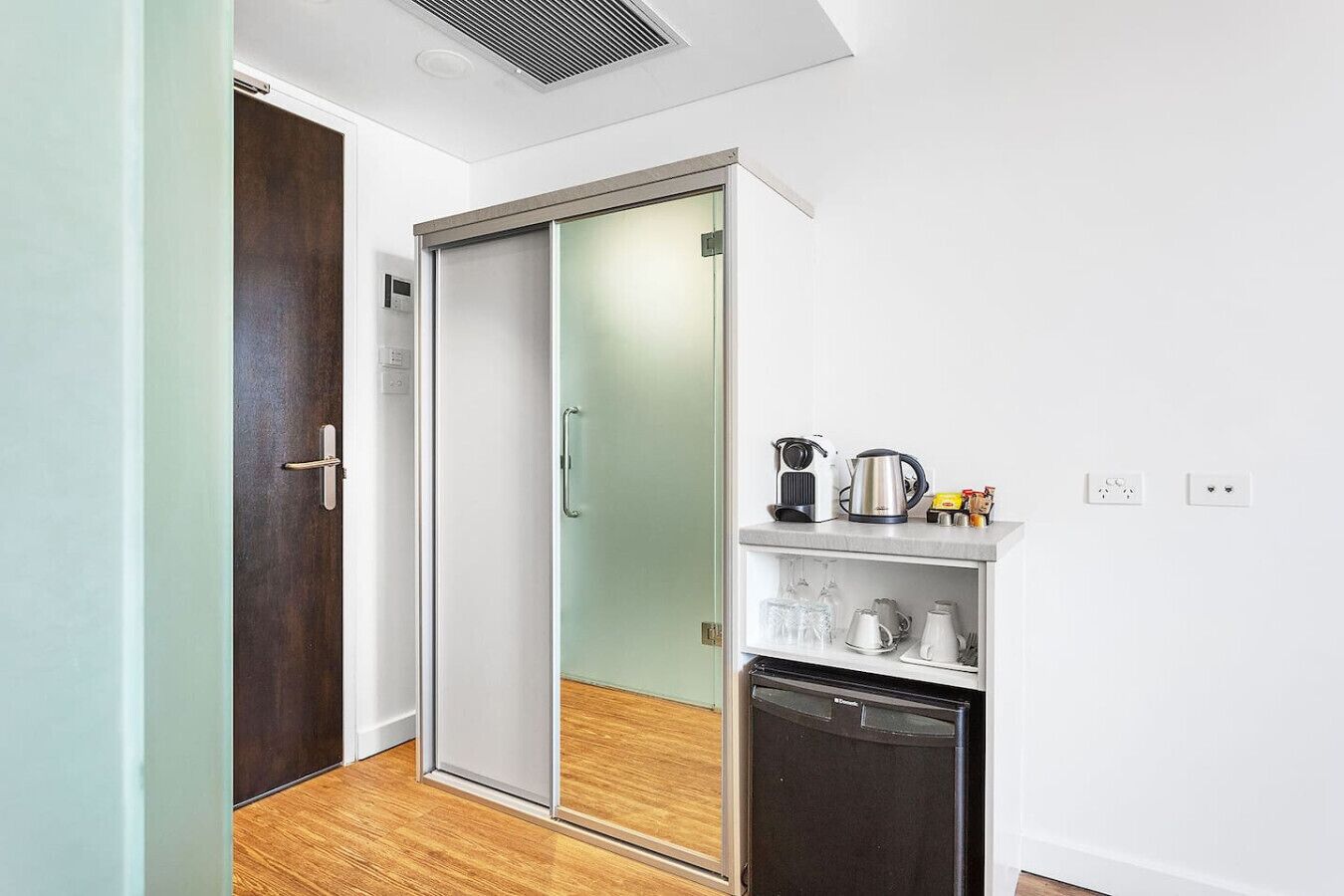 A modern kitchen with a sliding glass door, a coffee maker, and a dishwasher.