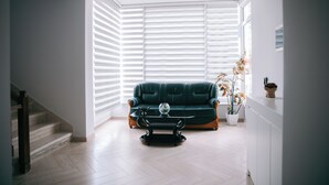 A living room with a green sofa, a coffee table, and a potted plant. - Vila Merkaj (Berat)