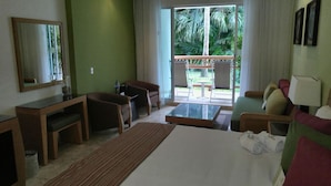 A hotel room with a bed, a desk, a chair, a small table, and a view of the outdoors. - Cozy 1-bedroom Suite with fitness room, AC in charming Nuevo Vallarta (Nuevo Vallarta)