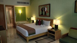 A hotel room with a bed, bedside lamps, a painting, and a green wall. - Cozy 1-bedroom Suite with fitness room, AC in charming Nuevo Vallarta (Nuevo Vallarta)