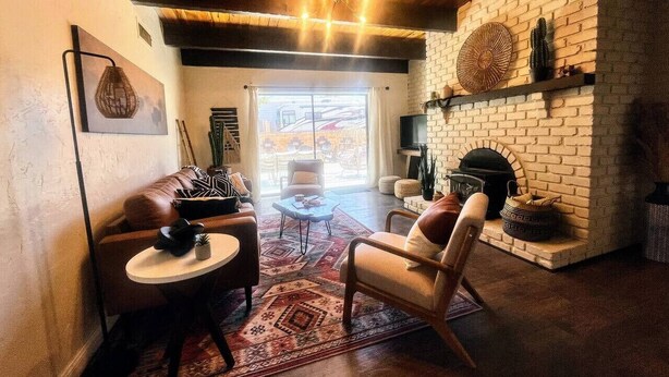A cozy living room with a fireplace, leather sofas, and a coffee table. - NEW! MiniGolf–PoolTable–FirePit–BBQ–Arcade–Bocce (Page)