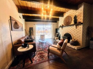 A cozy living room with a fireplace, leather sofas, and a coffee table. - NEW! MiniGolf–PoolTable–FirePit–BBQ–Arcade–Bocce (Page)