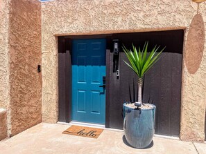 A blue door with a keyhole and a small potted plant beside it. - MiniGolf–PoolTable–FirePit–BBQ–Arcade–Bocce Ball (Page)
