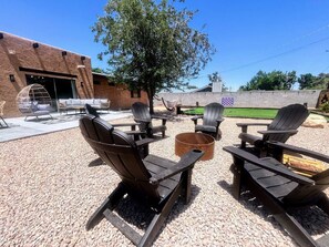 An outdoor seating area with Adirondack chairs and a fire pit. - MiniGolf–PoolTable–FirePit–BBQ–Arcade–Bocce Ball (Page)