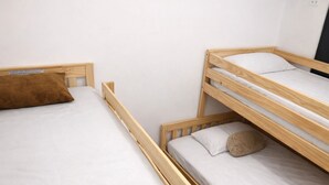 A bunk bed with a single bed on the left and a lower bunk on the right, both with white bedding and pillows. - Room AREAS by QuBeLab (Bello)