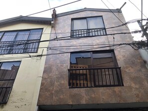 A multi-story building with balconies and a tiled facade.