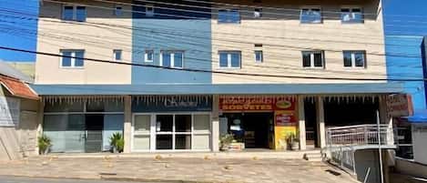 Un edificio de varios pisos con un local comercial en la planta baja y viviendas en los niveles superiores.