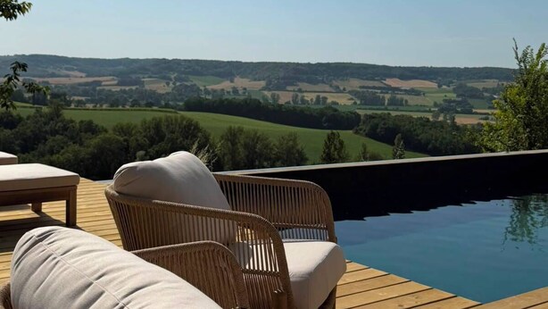 Une terrasse en bois avec des meubles en osier et une piscine.
