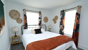 A bedroom with a bed, two bedside tables, a lamp, and decorative wall art. - Comfortable 4BR Home Near Downtown Elyria (Elyria)