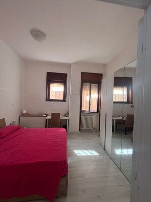 A bedroom with a bed, a desk, a chair, a radiator, and a mirror. - Apartment 'Rob' with Private Terrace and Air Conditioning (Lecce)