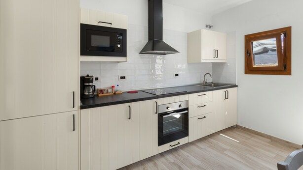 Eine moderne Küche mit Mikrowelle, Backofen und Spüle.