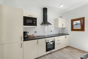 Eine moderne Küche mit Mikrowelle, Backofen und Spüle.