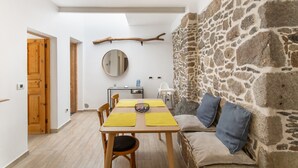 A dining area with a table, chairs, and a stone wall.