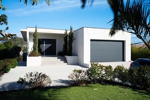 A modern two-story house with a white exterior, a garage, and a well-maintained lawn. - Villa Saint Aygulf - Vue mer avec Piscine Privée (Saint-Aygulf)