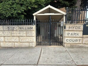 Una entrada cerrada con un muro de ladrillo con la leyenda '587 WILLIAM' y 'HYDE PARK COURT' a la derecha.