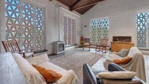 A spacious room with a large bed, a sofa, a TV, and a fireplace. - Double Room 3 in Farmhouse Surrounded by Nature (Castiglione Chiavarese)