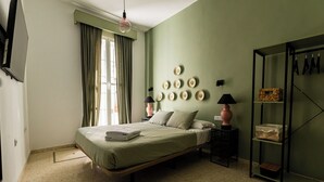 A bedroom with a bed, a wardrobe, a window with curtains, and wall-mounted plates. - HN Salteras (Salteras)
