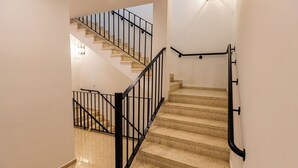 A staircase with a handrail and a light fixture on the wall. - HN Salteras (Salteras)