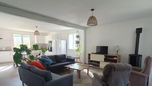Un salon moderne comprenant un canapé, des fauteuils, une table basse et un meuble pour la télévision.