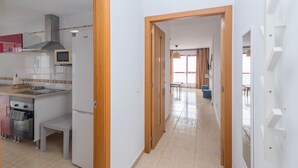 A modern kitchen with a built-in oven, microwave, and a dining area with a bench and table. - 2BR BuenaVida Residential - Mountain Views 2ºD (Breña baja)