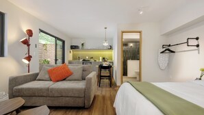 Un ambiente moderno e funzionale con angolo cottura, zona pranzo e camera da letto.