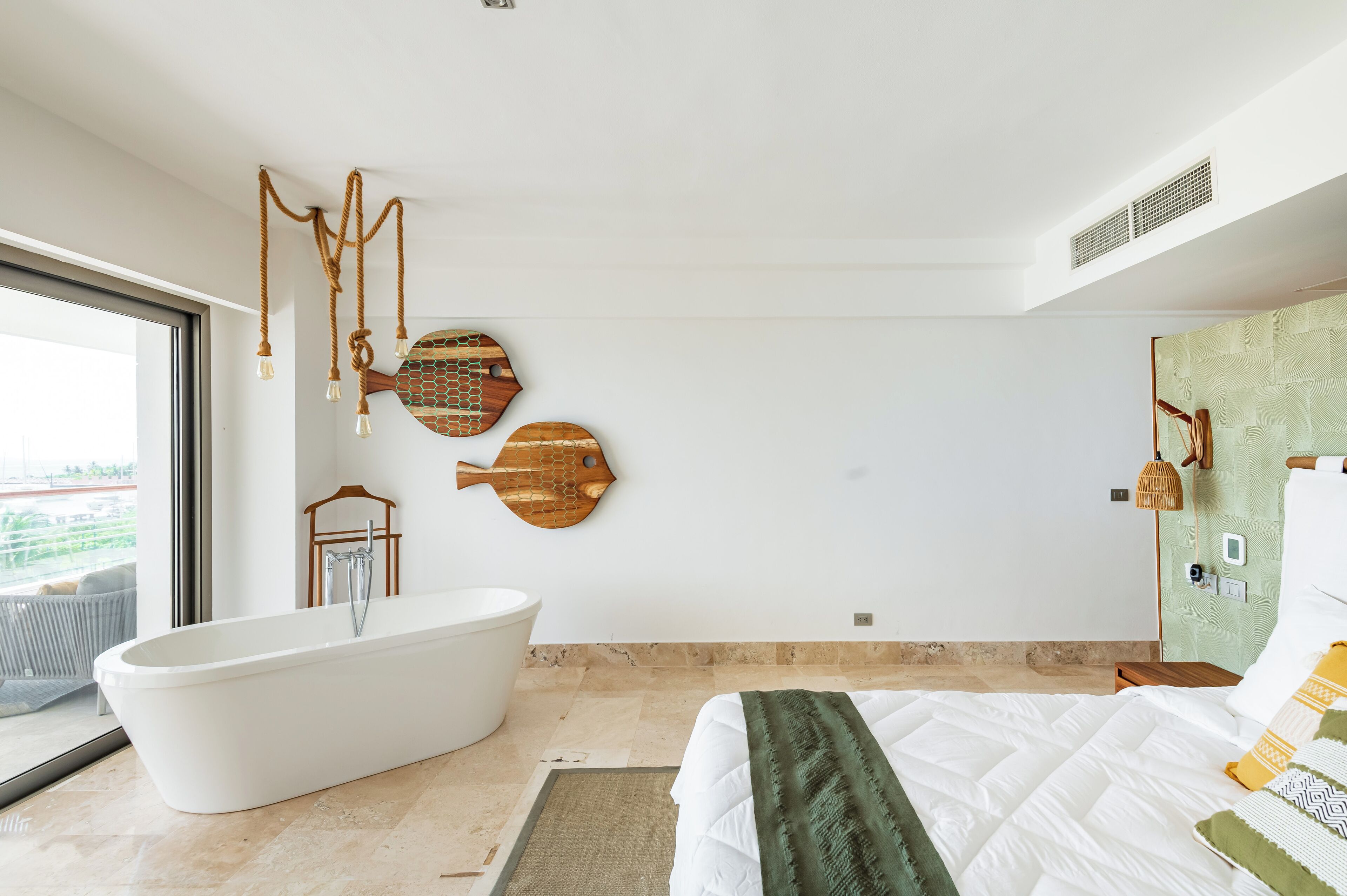 A modern bathroom with a freestanding bathtub, a large mirror, and a wooden fish-shaped wall decoration.