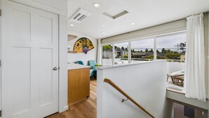 Un intérieur moderne avec un meuble en bois, un ventilateur et une vue sur l’extérieur.