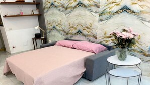 A modern bedroom with a bed, a small round table, and a decorative vase. - Anema& Core house entire accommodation a stone's throw from Via Toledo - Naples (Napoli)