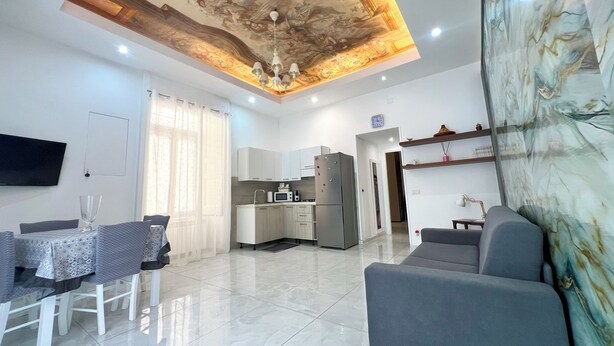 A modern living room with a dining area, a kitchen, and a large ceiling mural. - Anema& Core house entire accommodation a stone's throw from Via Toledo - Naples (Napoli)