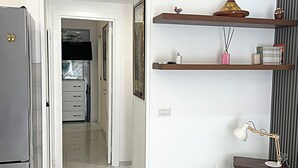 A kitchen with a refrigerator, a clock, and a hallway leading to a dining area. - Anema& Core house entire accommodation a stone's throw from Via Toledo - Naples (Napoli)