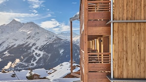 A wooden cabin with a balcony overlooking a snowy mountain landscape. - À proximité des pistes | Piscine sur place (Montvalezan)