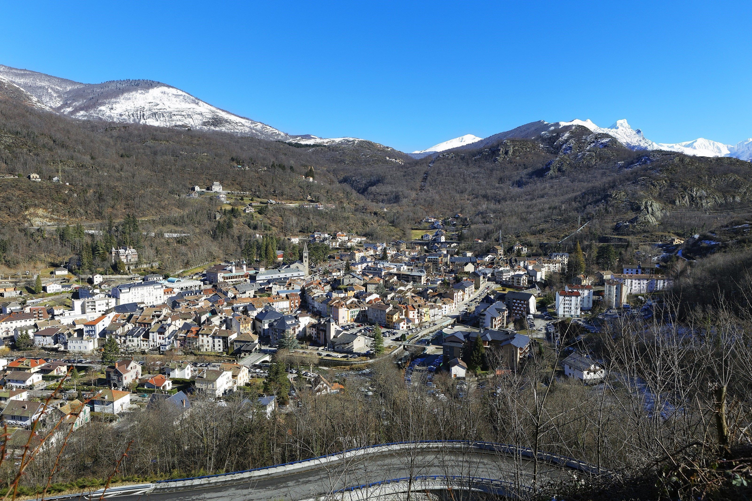 Une ville nichée dans une vallée, avec des montagnes enneigées en toile de fond.