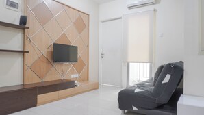 A modern living room with a TV mounted on a wooden partition, a sofa, and a sliding door. - Warm And Cozy 2Br At Pakubuwono Terrace Apartment (Jakarta)