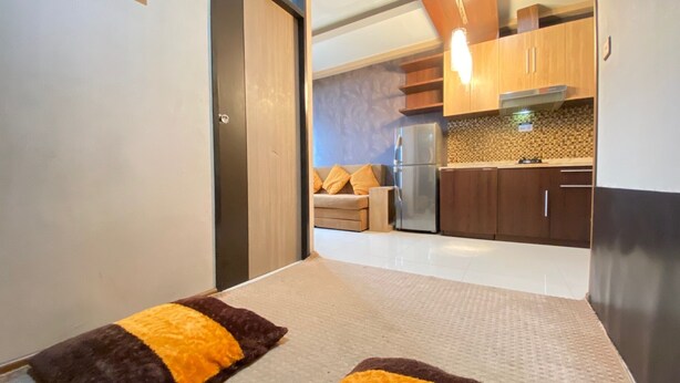 Une cuisine moderne avec des meubles en bois, un réfrigérateur en acier inoxydable et un pare-feu décoratif.