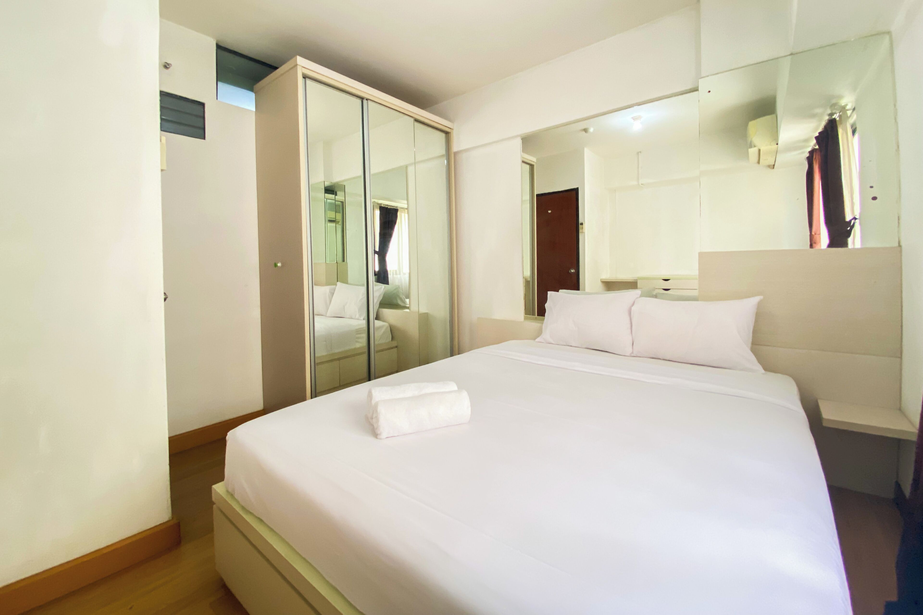 Ein Hotelzimmer mit einem großen Bett, einem Kleiderschrank und einem Spiegel.